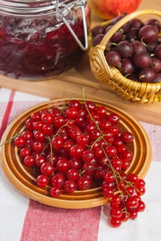 Jam with berries of red currant and gooseberry on the table