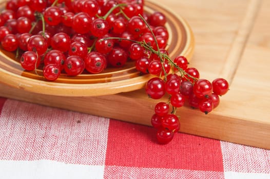 Berries of a red currant in a plate on a table