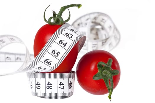 Healthy Eating - Weight Loss with Measure - Measuring Tape Guided by a Fork with Two Tomatoes Against White Background