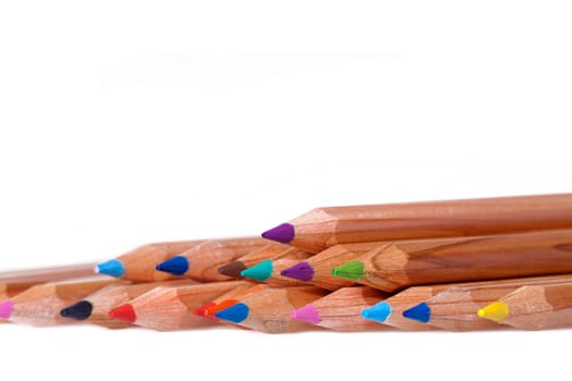 Colored crayons in a row as a close-up shot against white background