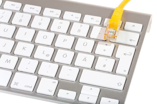 Network cable to keyboard - Yellow network cable lying on modern computer keyboard against white background