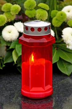Illuminated votive candle glows on a grawe lantern