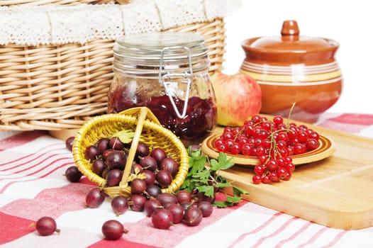 Jam with berries of red currant and gooseberry on the table