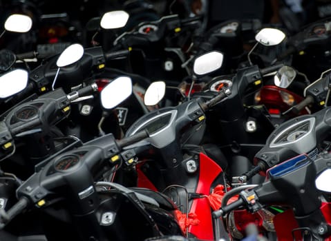 a closeup of several rearview mirrors of motorbikes in a parkinglot