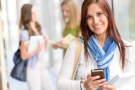 Female student listen mp3 player in high school hall