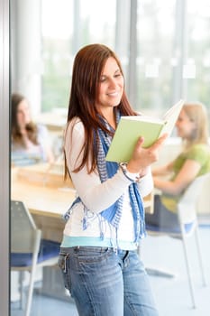 Female teenager student reading book at high school study room