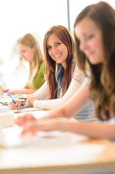 Smiling student teenager studying at classroom high school