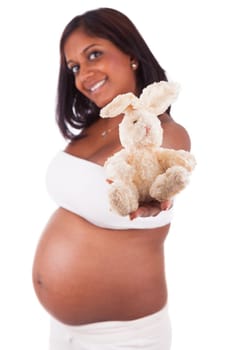 Young pregnant indian woman holding a plush, isolated on white background