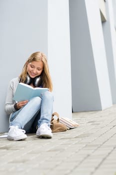 Smiling young study woman read book outdoor high-school building