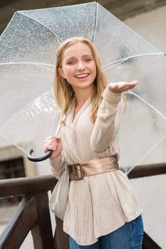 Young happy woman in rain with umbrella city look