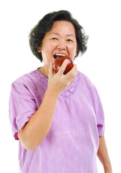 Healthy lifestyle concept. Asian senior woman eating an apple over white background