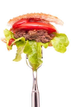 Hamburger with beef,lettuce leaf,tomato and ketchup on a fork