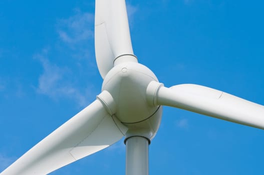 closeup of a windturbine against a blue sky
