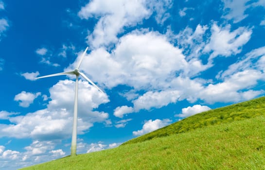 wind turbine on a hill under a cloudy blue sky