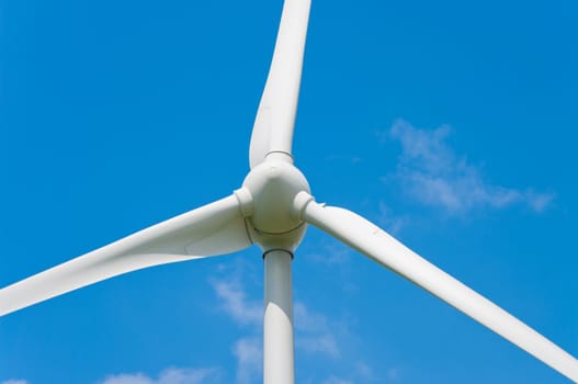 closeup of a windturbine against a blue sky