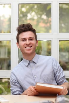Young adult man holding notes book