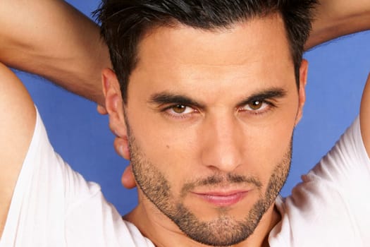 Handsome 30 years old man with black hair and brown eyes portrait over a light blue background
