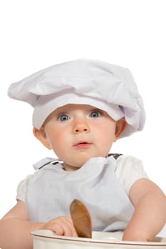Adorable baby in chefs hat playing with a wooden spoon and bowl with a wide-eyed expression of awe and amazement isolated on white