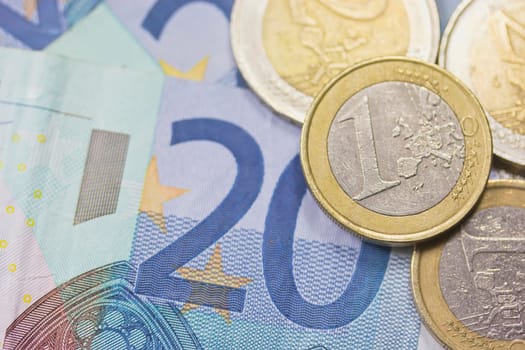 Detailed view of euro coins lying on paper money. Background.