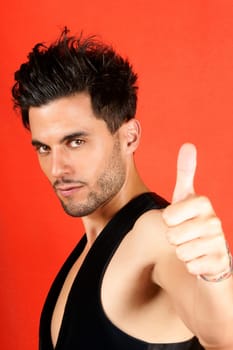Smiling attractive 30 years old man with thumbs up over an orange background