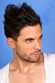 trendy 30 years old man with black hair and brown eyes portrait over a light blue background