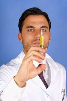 Mid adult doctor holding a syringe with yellow medicine. With copy space