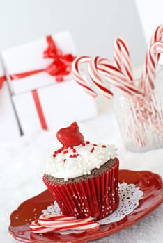 Chocolate cupcake with vanilla frosting, decorated with a edible ornament and pearls.