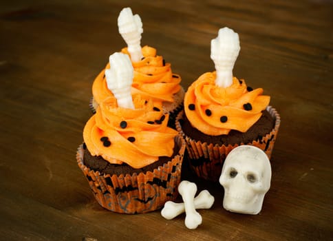 Chocolate cupcakes decorated with white chocolate skeleton parts.
