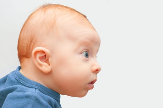 Side View of Sweet Curious Baby on Light Background