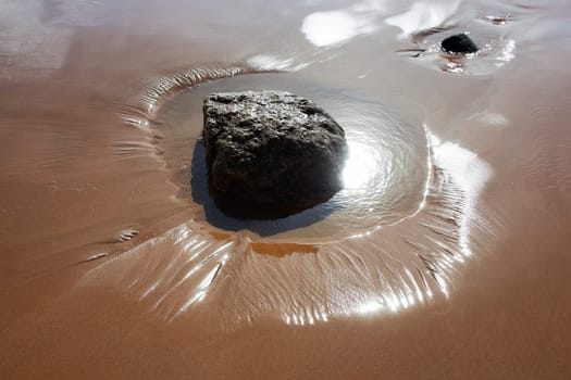Stone in sand at the beach in Agadir at the Atlantic coast, Morocco.