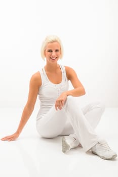 Attractive blonde woman relaxing during Pilates exercise on white background
