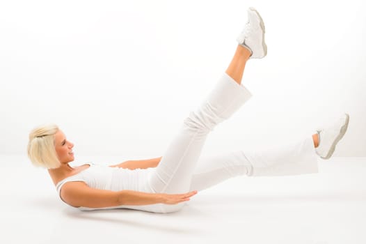 Blond fitness woman doing abdominal exercises smiling at gym workout