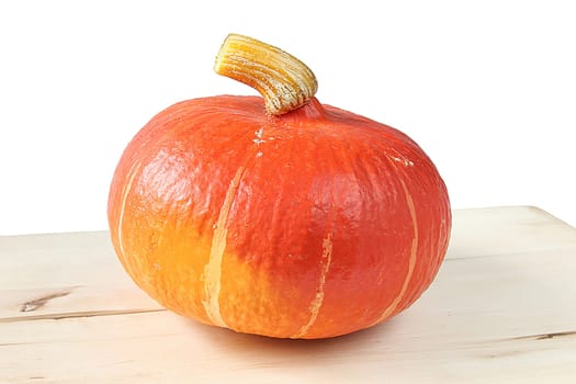 whole Hokkaido pumpkin on cutting board against white background