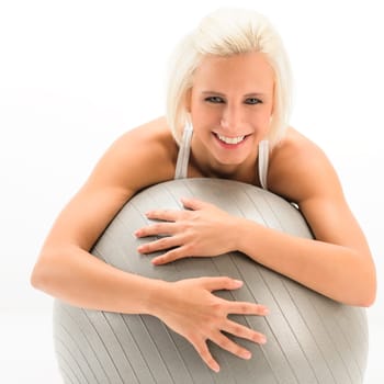 Smiling woman exercising on fitness ball on white background