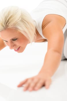 Young sportive woman doing push-ups on white background fitness exercise
