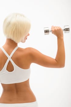 Back view portrait muscular blond woman holding dumbbell on white