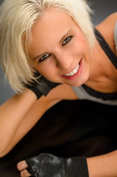 Female kick boxer laying down on black floor close-up portrait