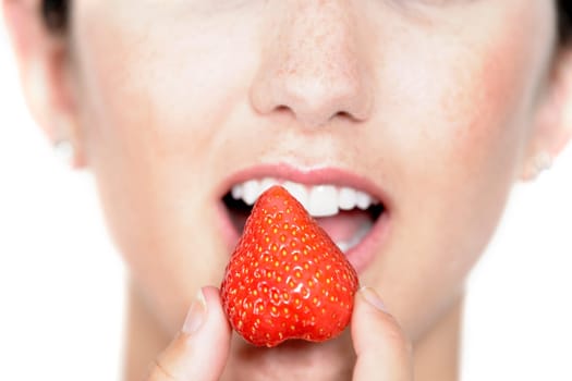 Beautiful young woman eating a fresh strawberry