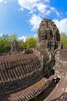 Massive stone faces decorating towers of Bayon temple in Angkor Thom, Cambodia