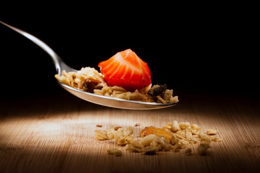 Close up image of granola and fruit on a spoon