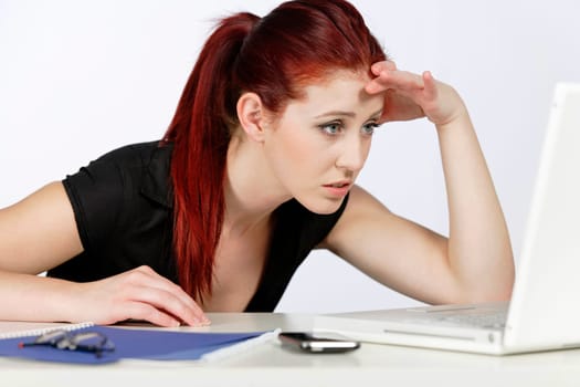 Professional woman showing concern at work using her laptop