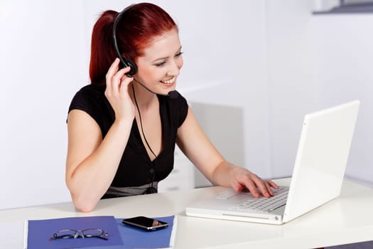Professional woman talking on a headset in her office at work