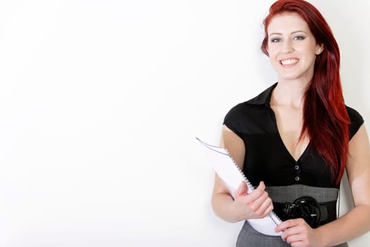 Professional young business woman in a smart dress holding folders and documents