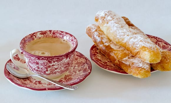 Coffee with milk, with fartons, buns species typical of Valencia, Spain