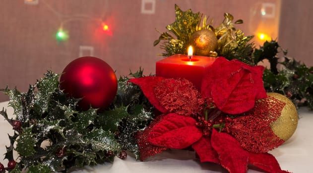 A red christmas candle amongst christmas decorations