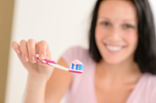 Close-up toothbrush with toothpaste with background woman before teeth hygiene