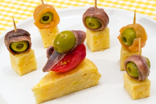 Delicious Appetizer Plate with Salmon, anchovies and Olives. Spanish tortilla mounted