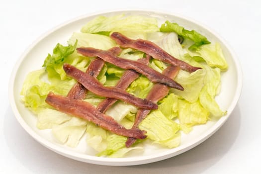 ration of anchovies in vinegar, garnished with tomato and mint