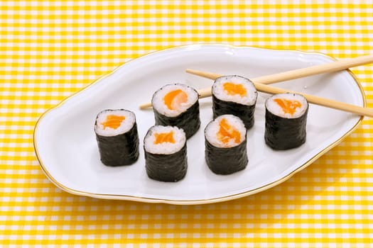 Makizushi. Delicious sushi rolls on white plate with chopsticks and wasabi. Maki