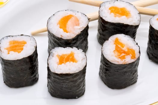 Makizushi. Delicious sushi rolls on white plate with chopsticks and wasabi. Maki